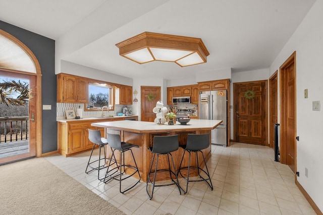 2108 Lawrence Dr, De Pere, WI 54115 - kitchen featuring stainless steel appliances, light countertops, a sink, and a kitchen bar