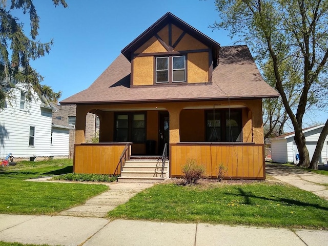 308 E Harrison St, Appleton, WI 54915 - bungalow-style home featuring covered porch, stucco siding, a front lawn, and roof with shingles