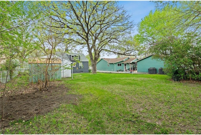 view of grassy yard featuring an outdoor structure and a storage unit