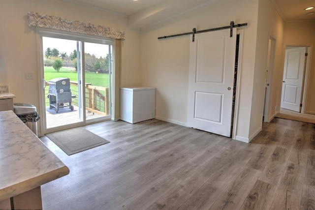 W5977 Lakeview Dr, Montello, WI 53949 - doorway to outside featuring a barn door, light wood finished floors, baseboards, and ornamental molding