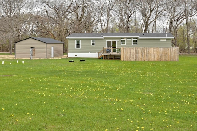 W5977 Lakeview Dr, Montello, WI 53949 - rear view of house featuring a lawn, a deck, an outbuilding, and view of scattered trees