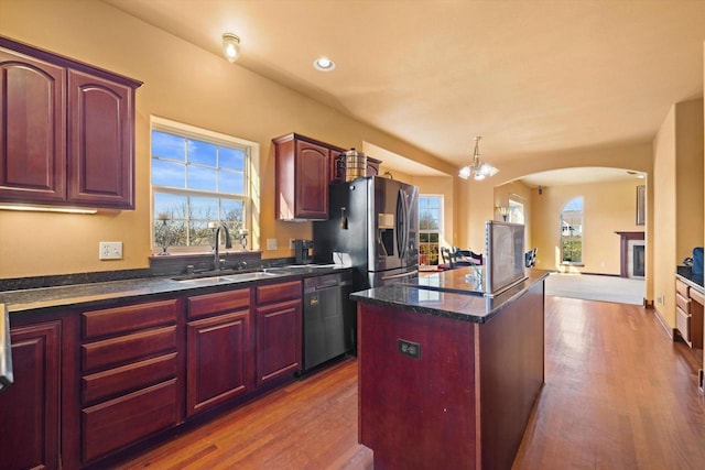 N109W14760 Preserve Pkwy, Germantown, WI 53022 - kitchen featuring a sink, arched walkways, stainless steel appliances, a kitchen island, and healthy amount of natural light