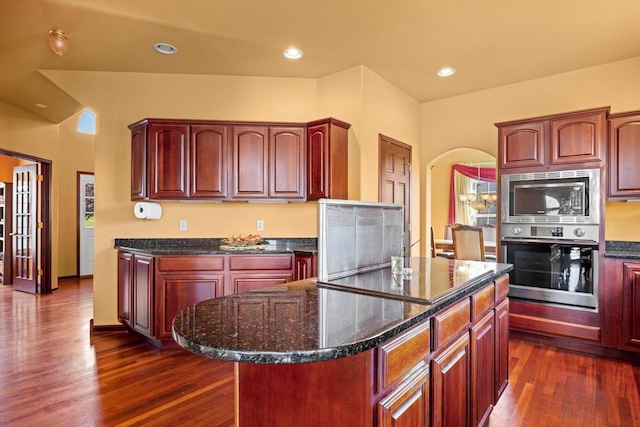 N109W14760 Preserve Pkwy, Germantown, WI 53022 - kitchen featuring stainless steel appliances, dark wood-type flooring, dark stone countertops, a kitchen island, and dark brown cabinets