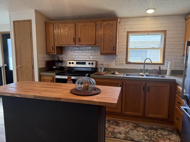 33150 Donna Dr Unit 14, Prairie Du Chien, WI 53821 - kitchen with wood counters, electric range, a sink, a textured ceiling, and backsplash