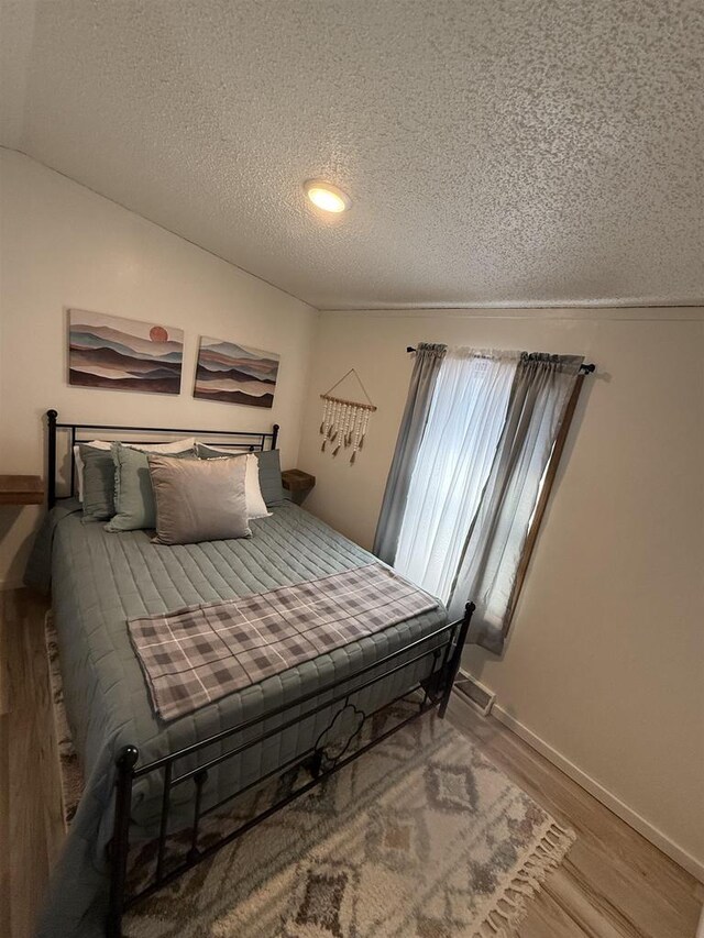 33150 Donna Dr Unit 14, Prairie Du Chien, WI 53821 - bedroom with a textured ceiling, wood finished floors, and baseboards