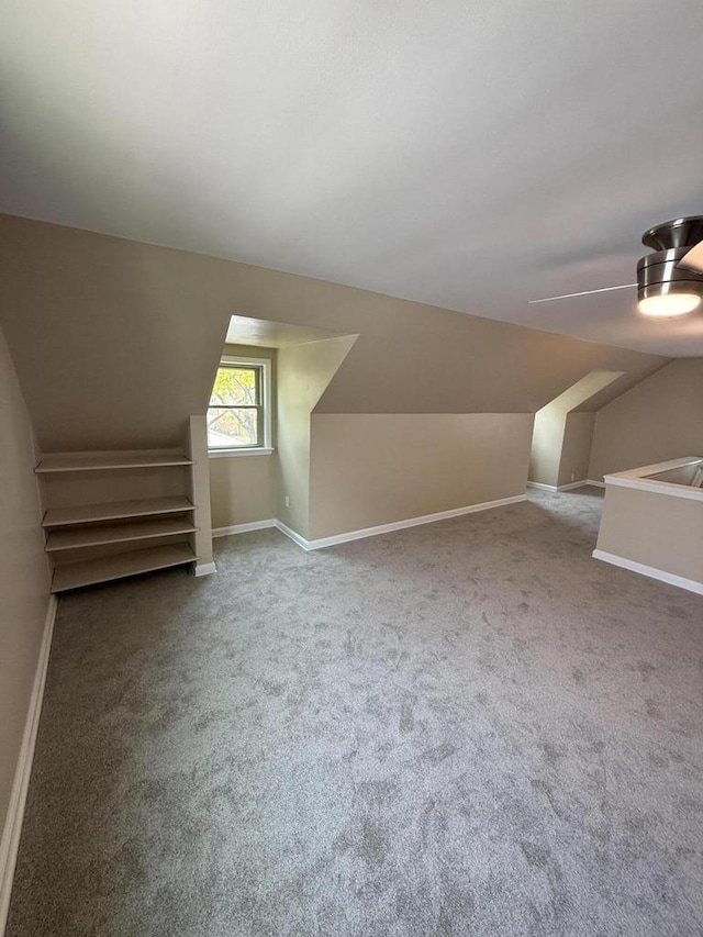 bonus room featuring carpet floors, vaulted ceiling, and baseboards