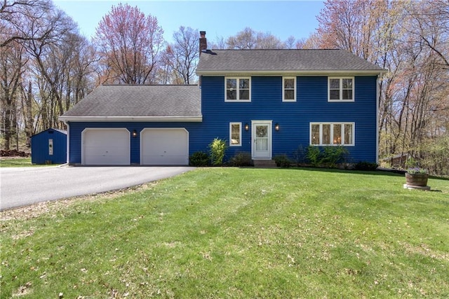 E1924 Kirk Ct, Eau Claire, WI 54701 - colonial home featuring a garage, a chimney, asphalt driveway, and a front yard