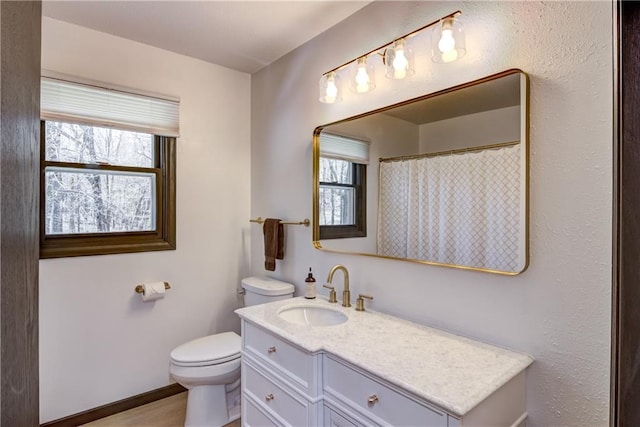 E1924 Kirk Ct, Eau Claire, WI 54701 - bathroom with healthy amount of natural light, toilet, vanity, and curtained shower