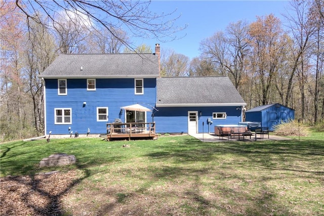 E1924 Kirk Ct, Eau Claire, WI 54701 - rear view of property featuring a chimney, a wooden deck, an outdoor structure, a storage unit, and a lawn