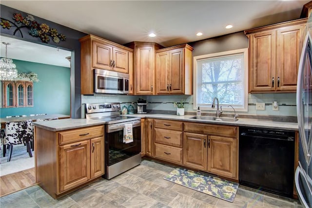 303 W Maple St, Thorp, WI 54771 - kitchen featuring appliances with stainless steel finishes, a sink, backsplash, a peninsula, and light countertops