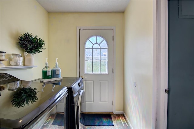 303 W Maple St, Thorp, WI 54771 - doorway with washing machine and clothes dryer and wood finished floors