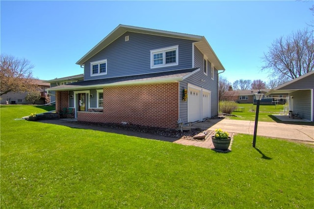 303 W Maple St, Thorp, WI 54771 - back of property featuring an attached garage, concrete driveway, and a yard