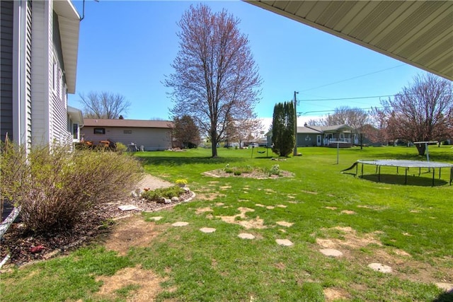 303 W Maple St, Thorp, WI 54771 - view of grassy yard featuring a trampoline