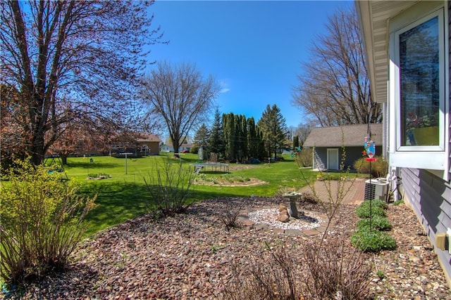 303 W Maple St, Thorp, WI 54771 - view of grassy yard featuring central air condition unit