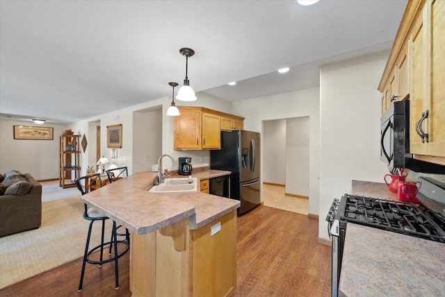 3271 Bay Hill Rd, Port Washington, WI 53074 - kitchen featuring black appliances, a sink, open floor plan, a peninsula, and a breakfast bar