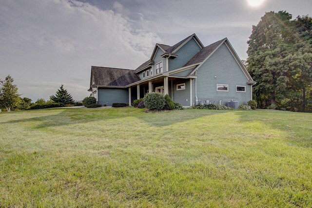 3271 Bay Hill Rd, Port Washington, WI 53074 - view of side of home with a lawn, a garage, central AC unit, and a shingled roof
