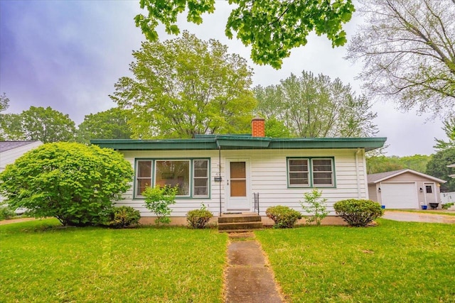 49 Schenk St, Madison, WI 53714 - single story home with a chimney, concrete driveway, a detached garage, a front yard, and an outbuilding