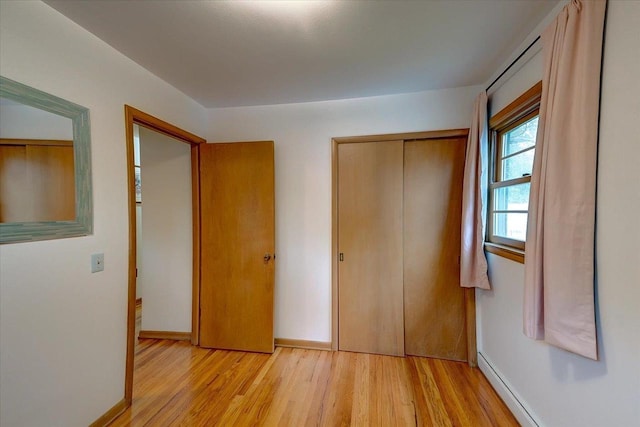 49 Schenk St, Madison, WI 53714 - unfurnished bedroom with light wood finished floors, a closet, baseboards, and baseboard heating
