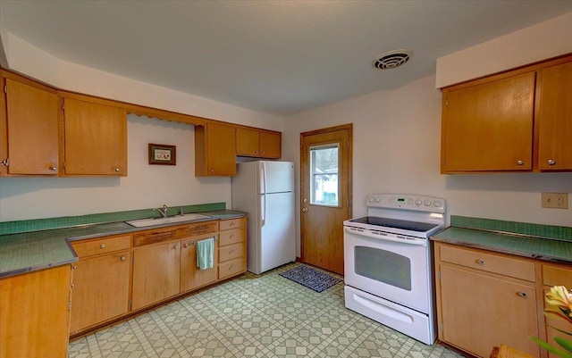 49 Schenk St, Madison, WI 53714 - kitchen with white appliances, a sink, light floors, brown cabinets, and dark countertops