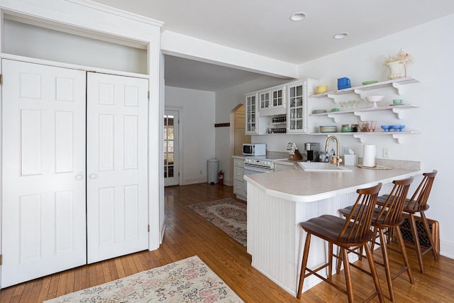 395 Lake St, Green Lake, WI 54941 - kitchen with a sink, white microwave, open shelves, a breakfast bar area, and glass insert cabinets
