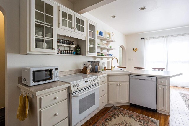 395 Lake St, Green Lake, WI 54941 - kitchen with white appliances, arched walkways, a sink, a peninsula, and recessed lighting