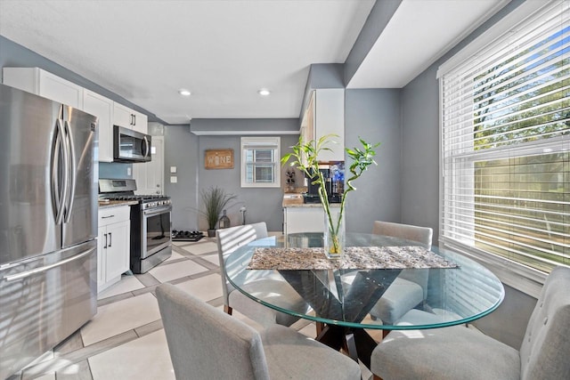 dining space with light tile patterned flooring and recessed lighting