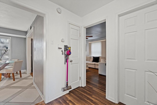 hallway with baseboards and wood finished floors