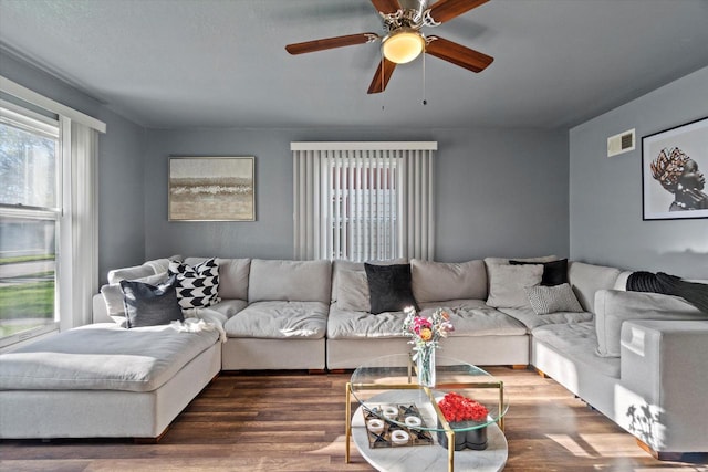 living area with wood finished floors and a ceiling fan