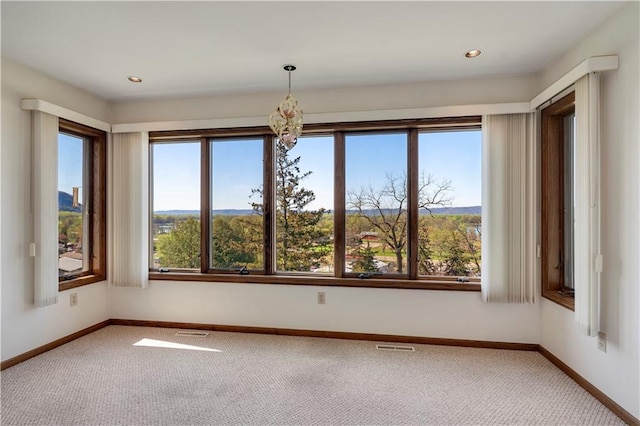 carpeted spare room featuring baseboards, a chandelier, and recessed lighting