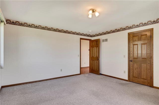 unfurnished room with light colored carpet and baseboards