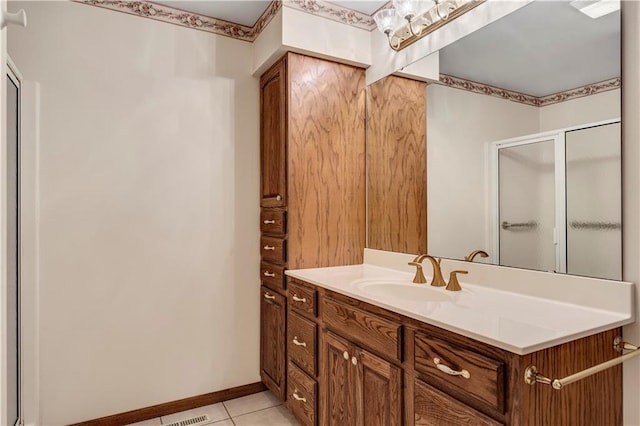 full bath with a stall shower, tile patterned floors, vanity, and baseboards