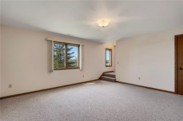 carpeted spare room with stairway and baseboards