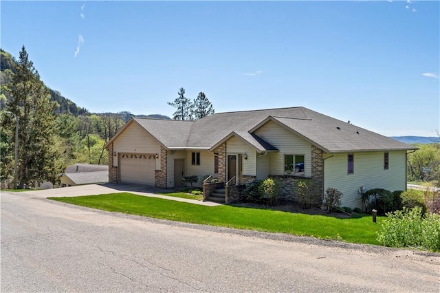 ranch-style house featuring a garage, driveway, and a front lawn