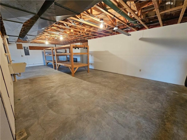 unfinished basement with electric panel and a sink
