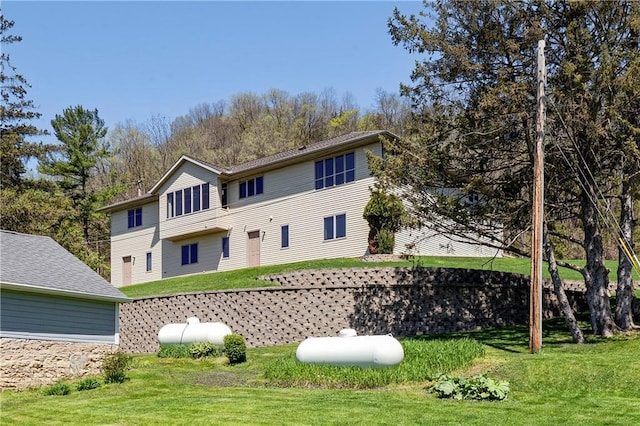 rear view of property featuring a lawn