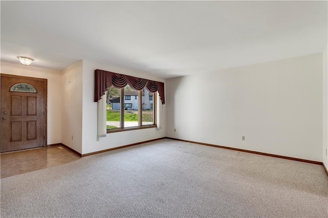 empty room featuring carpet flooring and baseboards