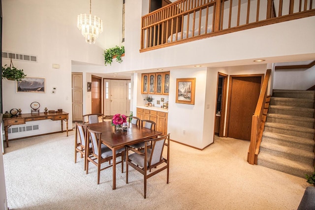 2415 Walnut Grove Ct Unit B, Brookfield, WI 53005 - dining room with light carpet, baseboards, stairway, a high ceiling, and a chandelier