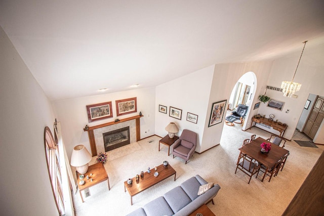2415 Walnut Grove Ct Unit B, Brookfield, WI 53005 - carpeted living room with a chandelier, arched walkways, a tiled fireplace, and lofted ceiling