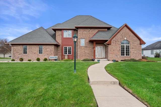 135 Emerald Dr, Mount Pleasant, WI 53406 - view of front facade featuring brick siding, a front yard, and a shingled roof