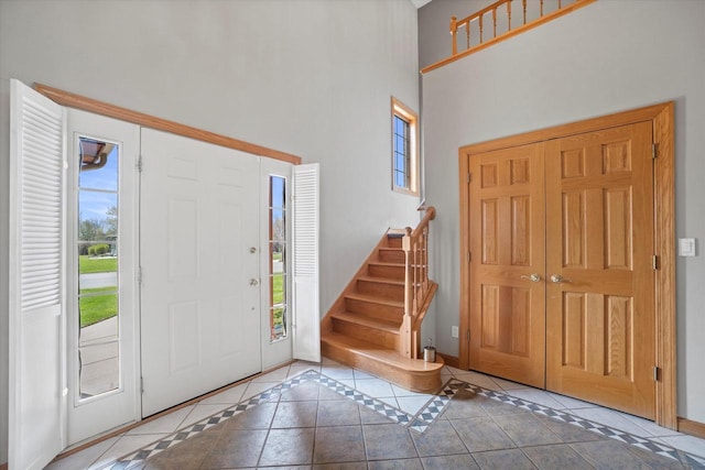 135 Emerald Dr, Mount Pleasant, WI 53406 - tiled entrance foyer featuring a towering ceiling, stairs, baseboards, and inlaid floor details