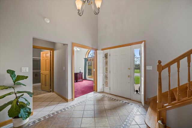 135 Emerald Dr, Mount Pleasant, WI 53406 - entryway featuring a towering ceiling, baseboards, stairs, a chandelier, and light tile patterned flooring