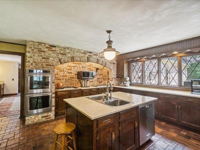 5140 N Kennedy Rd, Milton, WI 53563 - kitchen with stainless steel appliances, a sink, light countertops, a kitchen island with sink, and healthy amount of natural light