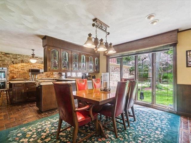 5140 N Kennedy Rd, Milton, WI 53563 - dining area featuring wainscoting, brick patterned floors, and wood walls