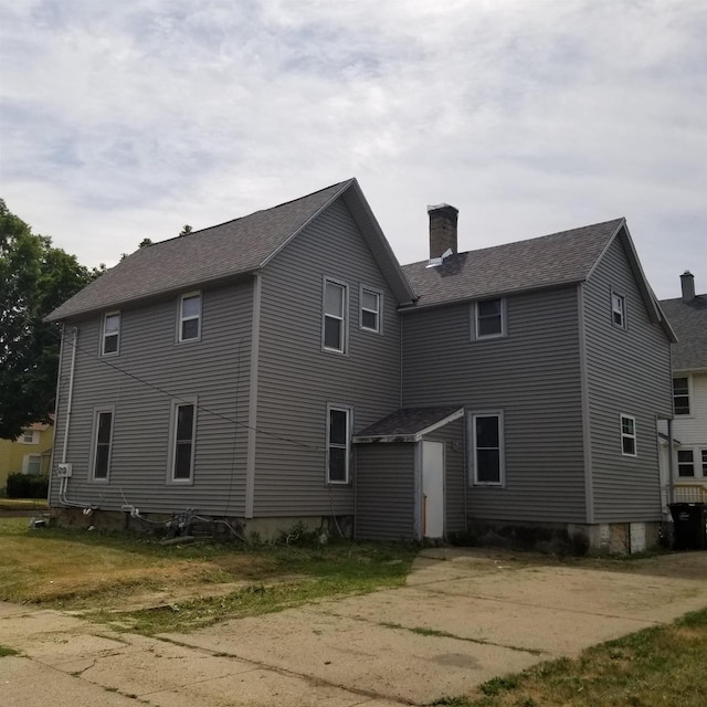 958 Elm St, Beloit, WI 53511 - rear view of house with a chimney, roof with shingles, a shed, and an outdoor structure