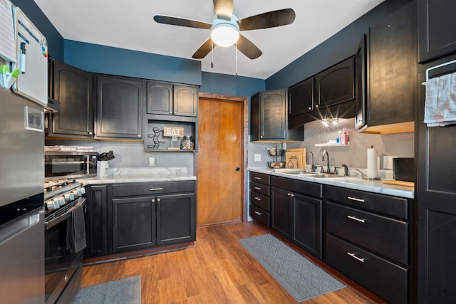 841 Legion Dr, Twin Lakes, WI 53181 - kitchen featuring stainless steel appliances, a sink, light countertops, light wood-type flooring, and ceiling fan