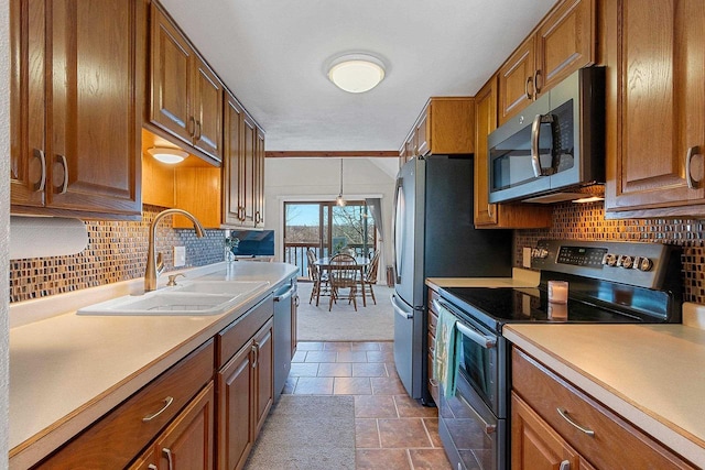 9331 N Marl Lake Rd, Pound, WI 54161 - kitchen with stainless steel appliances, a sink, brown cabinetry, dark stone finish flooring, and light countertops