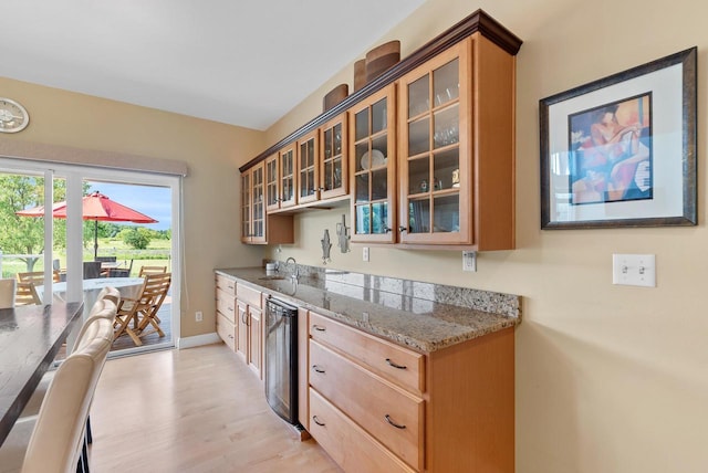W4344 Carl Dr, Fond Du Lac, WI 54937 - kitchen featuring beverage cooler, glass insert cabinets, light wood finished floors, light stone counters, and baseboards