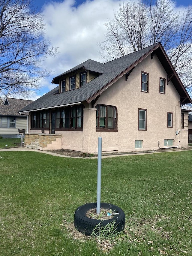 1040 N 1st St, Wisconsin Rapids, WI 54494 - back of property with roof with shingles, a lawn, and stucco siding