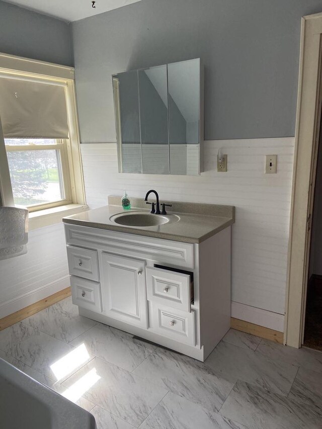 1040 N 1st St, Wisconsin Rapids, WI 54494 - bathroom featuring marble finish floors, wainscoting, and vanity