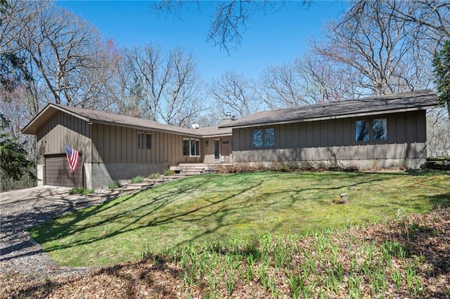 1395 25th St, Houlton, WI 54082 - rear view of house with driveway, board and batten siding, a yard, and a garage